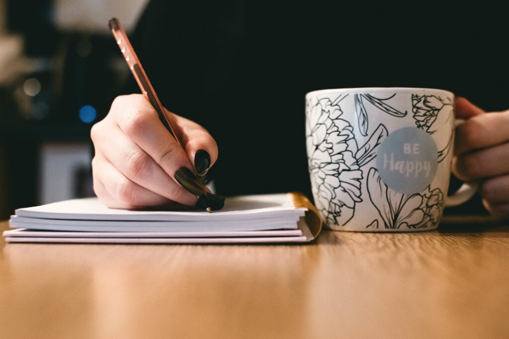 Person-Holding-White-Ceramic-Be-Happy-Painted-Mug