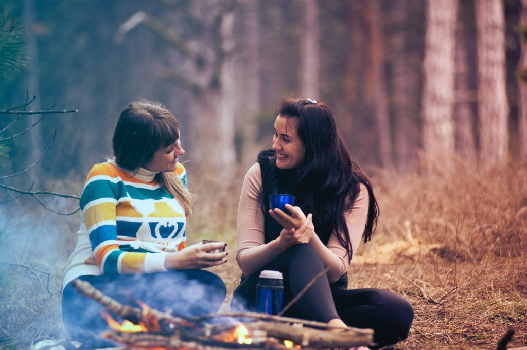 two-women-sitting-on-ground-near-bonfire